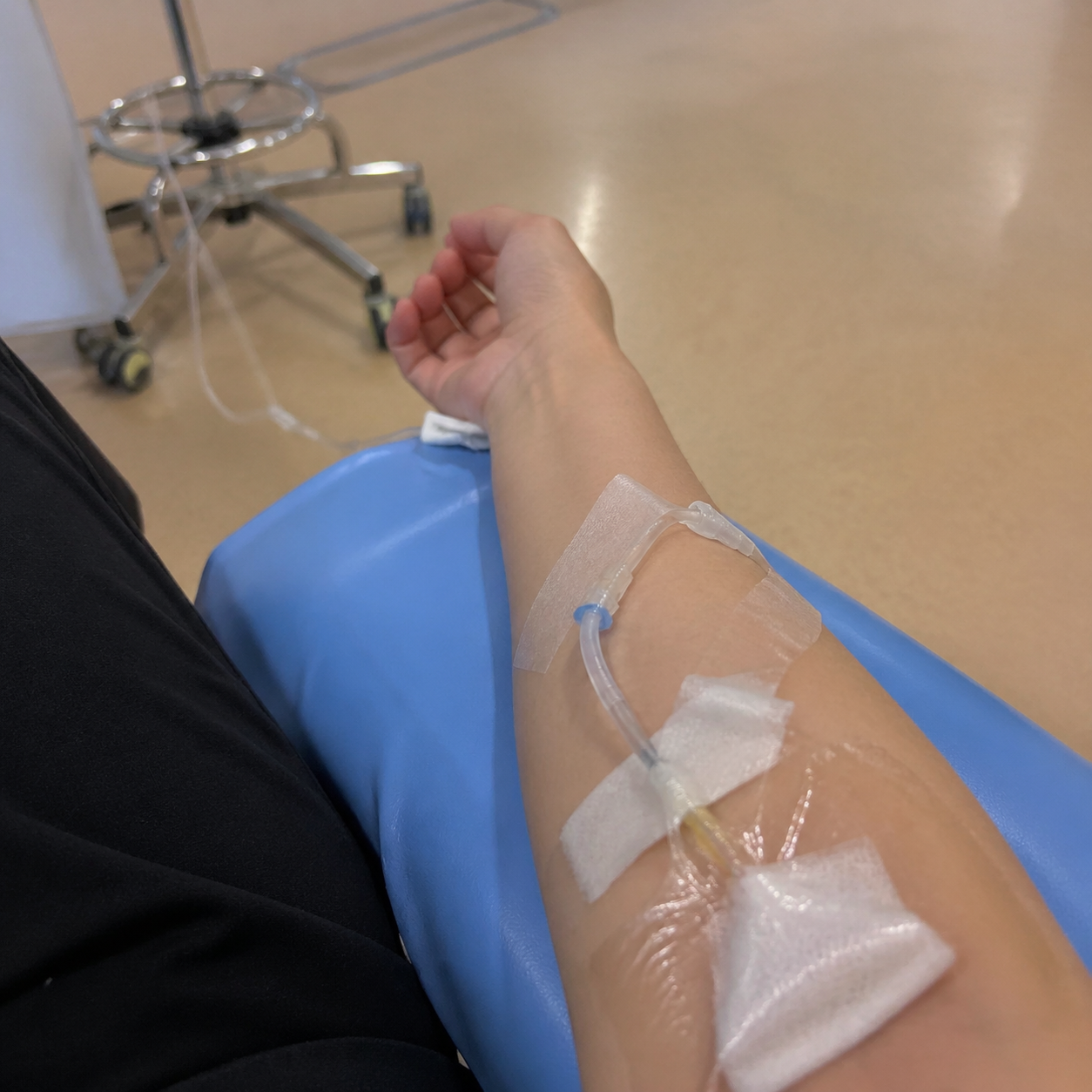 帮我生成一张在医院输液的图片，画面是我的胳膊上插着输液的针头，看起来像是我用手机相机拍的照片