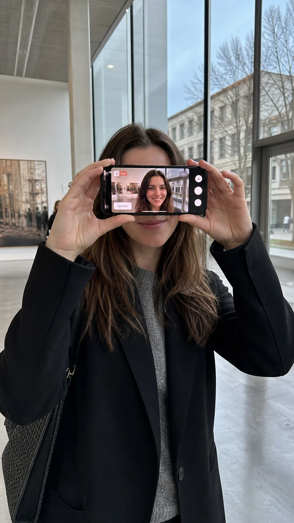 Berliner Galerieporträt mit Gesicht auf dem Smartphone-Bildschirm