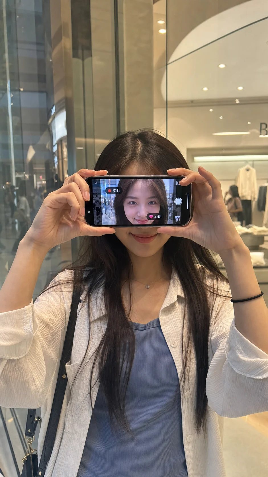 Porträt in einem Einkaufszentrum in Shanghai mit Gesicht auf dem Smartphone-Bildschirm